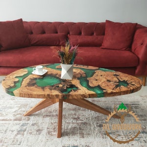 May include: A green and brown oval coffee table with a live edge design and a resin pour. The table has a natural wood base with four legs.