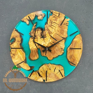 May include: A round wooden clock with a turquoise blue epoxy resin inlay. The clock face has black hands and black Roman numeral markings.