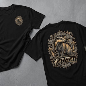 May include: Two black t-shirts. One has a small badger emblem on the chest. The other features a detailed illustration of a badger within a decorative frame, with the word "Hufflepuff" below, in a vintage style.