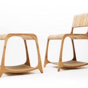 May include: A set of two wooden chairs with curved backs and legs. The chairs are made of light brown wood and have a simple, modern design.
