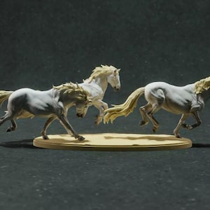May include: A sculpture of three white horses in mid-gallop. The horses have flowing manes and tails, and are mounted on a light brown, oval base. The background is a dark, neutral color.