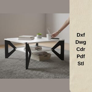 Puede incluir: Una mesa de centro blanca moderna con soportes geométricos negros y un estante inferior. La mesa tiene libros, una pequeña planta y una cesta tejida. Una persona sostiene una taza blanca con vapor. Texto: Dxf, Dwg, Cdr, Pdf, Stl.