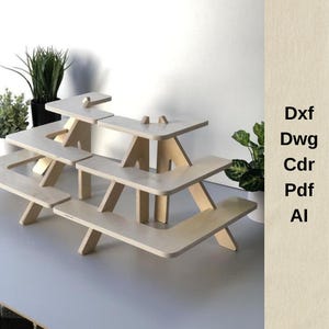 Op de afbeelding: Een drielaags houten displaystandaard gemaakt van licht hout. De standaard is gevormd als een reeks verbonden picknicktafels.