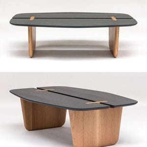 K&ouml;nnte beinhalten: Ein rechteckiger Couchtisch in Dunkelgrau mit einer einzigartigen geteilten Tischplatte und Holzbeinen. Der Tisch hat ein modernes Design und ist aus hochwertigen Materialien gefertigt.