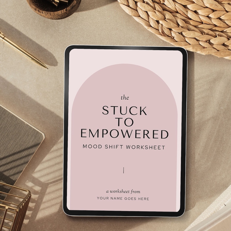 May include: A digital tablet displaying a pink and white mood shift worksheet titled "The Stuck to Empowered Mood Shift Worksheet". The worksheet is a printable PDF from "Your Name Goes Here".