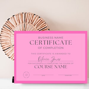 May include: A pink certificate of completion with the text "BUSINESS NAME CERTIFICATE OF COMPLETION" at the top. The certificate is awarded to "Olivia Jones" for successfully completing the course of "COURSE NAME".