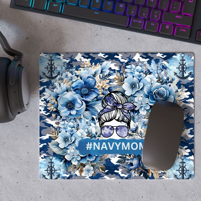 May include: A blue and gray camouflage mousepad with a floral design and a cartoon woman with a bun and sunglasses. The text "#NAVYMOM" is printed on the mousepad.