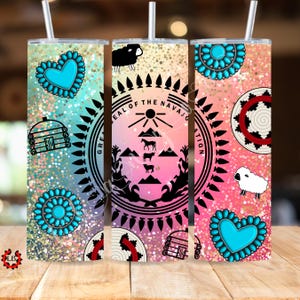 Puede incluir: Tres diseños de sublimación para un vaso con un corazón turquesa, una flor turquesa y el sello de la Nación Navajo. Los diseños están sobre un fondo de purpurina rosa y azul.