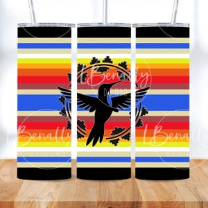 May include: A tall tumbler with a black, white, blue, yellow, orange, and red striped pattern. The tumbler features a black hummingbird design with a circular gear-like border. The tumbler has a straw and a lid.