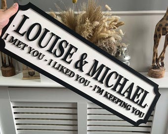 Può includere: Un cartello di legno bianco con lettere nere che recita "Louise & Michael. I met you - I liked you - I'm keeping you."