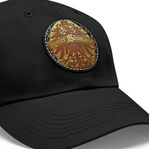 May include: Black cotton baseball cap with a round, brown leather patch featuring a gold eagle and the text "Otto Bismarck".