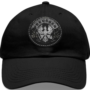 May include: Black baseball cap with a white distressed graphic of a coat of arms with an eagle and the word "Preussen".