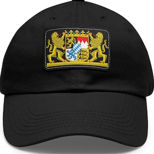 May include: Black baseball cap featuring a rectangular patch with a detailed coat of arms. The patch includes a shield with various emblems, flanked by two golden lions. The coat of arms has a white border.