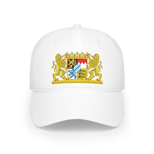 Könnte beinhalten: Weiße Baseballkappe mit einem goldenen gestickten Wappen mit zwei Löwen und einem Schild mit einem Schachbrettmuster.