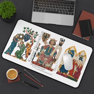 Puede incluir: Alfombrilla de ratón rectangular blanca con una ilustración medieval del emperador Enrique VI. El diseño incluye figuras con túnicas coloridas, escudos y texto en alemán. Un ratón de ordenador descansa sobre la alfombrilla.