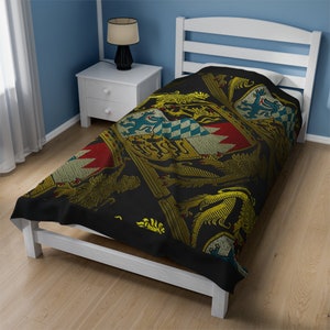 May include: A black twin-size bedspread with a gold and red heraldic design featuring lions and shields.