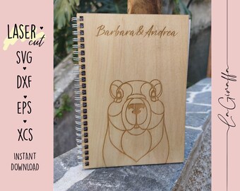 May include: A wooden notebook with a spiral binding. The cover features a line drawing of a marmot and the text "Barbara & Andrea".