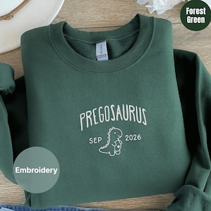 Puede incluir: Una taza de cerámica blanca con un asa negra y el texto "But First, Coffee" en un estilo manuscrito. La taza está sobre una superficie blanca. La taza mide aproximadamente 10 cm de alto.