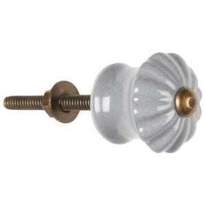 May include: A gray ceramic cabinet knob with a fluted design and a brass screw. The knob has a slightly textured surface.