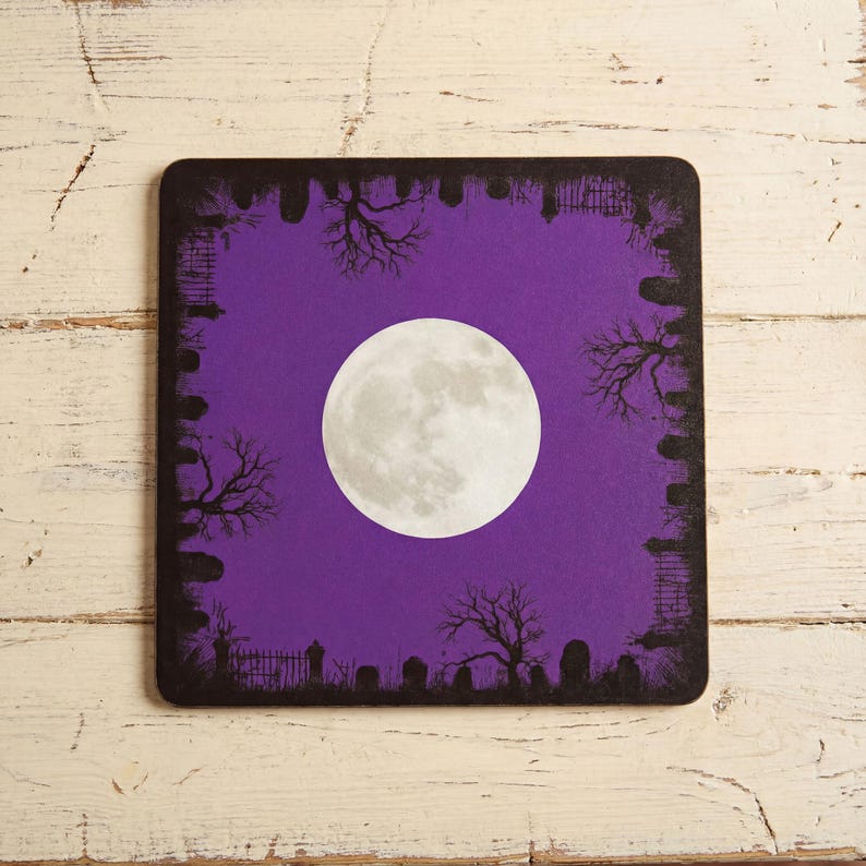 K&ouml;nnte beinhalten: Ein quadratischer Untersetzer mit einem leuchtend violetten Hintergrund und einem gro&szlig;en, zentrierten Vollmond. Der Rand ist mit schwarzen Silhouetten von kahlen B&auml;umen, Grabsteinen und Eisenz&auml;unen verziert, was eine dunkle, atmosph&auml;rische Szene schafft.