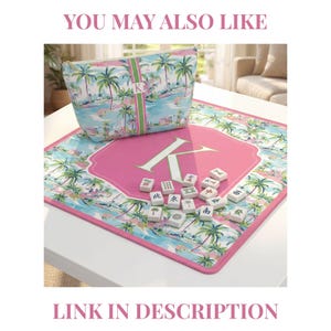 May include: A square mahjong mat and a matching zippered pouch featuring a tropical palm tree print in shades of blue, green, and pink. The mat has a large pink central hexagon with a white letter K, and the pouch displays a vertical green stripe.