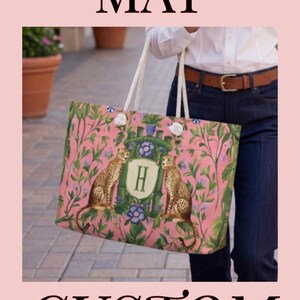 May include: Pink custom Mahjong mat and bags with a floral and cheetah print. The bags and mat feature an initial in a decorative frame. The mat is surrounded by green trim. Mahjong tiles are visible.