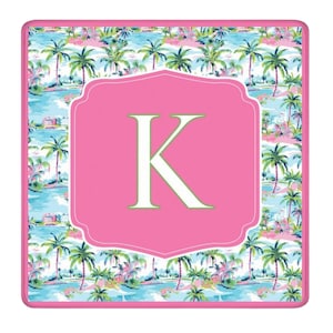 May include: A square, decorative mousepad featuring a tropical scene with palm trees, water, and buildings. A pink, scalloped frame surrounds a large, white letter "K" on a pink background. The border is pink.
