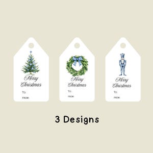 May include: Three white Christmas gift tags with watercolor designs. One features a Christmas tree, another a wreath with a blue bow, and the third a nutcracker. Each tag has "Merry Christmas" and space for "To:" and "From:."