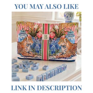 Puede incluir: Un bolso tote con un dise&ntilde;o colorido con leopardos, jarrones azules y blancos y follaje tropical. El bolso tiene una franja rosa y verde con la letra "B". La imagen tambi&eacute;n incluye fichas de mahjong azules. El texto dice "YOU MAY ALSO LIKE" y "LINK IN DESCRIPTION".