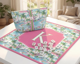 May include: A tropical-themed Mahjong set with a pink and white mat featuring a large letter "K" and a matching cosmetic bag. The set includes white tiles with Chinese characters and a palm tree design.