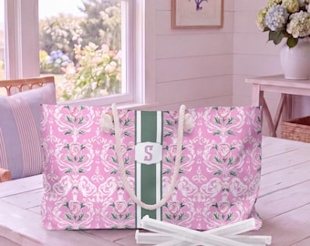 May include: A rectangular tote bag featuring a pink and white damask floral pattern with a central vertical sage green stripe. The bag includes white rope handles and a white rectangular patch displaying the letter S in a serif font.