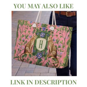 May include: A rectangular tote bag with white rope handles featuring a pink background with a green botanical pattern, two leopards, and a central crest displaying the letter H. The text YOU MAY ALSO LIKE and LINK IN DESCRIPTION is visible.