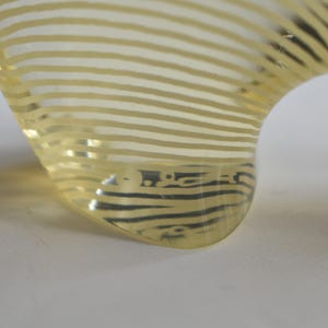 K&ouml;nnte beinhalten: Eine gelbe Glassch&uuml;ssel mit einem gestreiften Muster. Die Sch&uuml;ssel ist klar und hat eine strukturierte Oberfl&auml;che.
