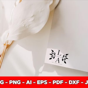 May include: A white card with the initials "LA" and the date "01.05.2025" in black, framed by floral elements. The card is on a white surface, with a white flower and stems in the upper left corner. The bottom of the image has the text "SVG - PNG - AI - EPS - PDF - DXF - JPG".