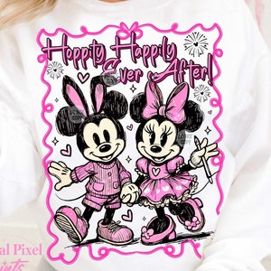 Könnte beinhalten: Weißer Pullover mit einem pinkfarbenen Motiv von Mickey Mouse und Minnie Mouse, die sich an den Händen halten. Das Motiv lautet "Hoppity Happily Ever After!" in pinkfarbenen Buchstaben.