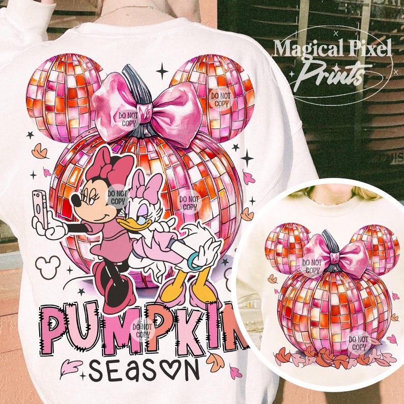 K&ouml;nnte beinhalten: Ein wei&szlig;es Sweatshirt mit einem pinkfarbenen und orangenen K&uuml;rbisdesign. Der K&uuml;rbis besteht aus einer Discokugel und hat eine rosafarbene Schleife oben drauf. Mickey Mouse und Daisy Duck stehen vor dem K&uuml;rbis. Der Text "Pumpkin Season" steht unter dem K&uuml;rbis.