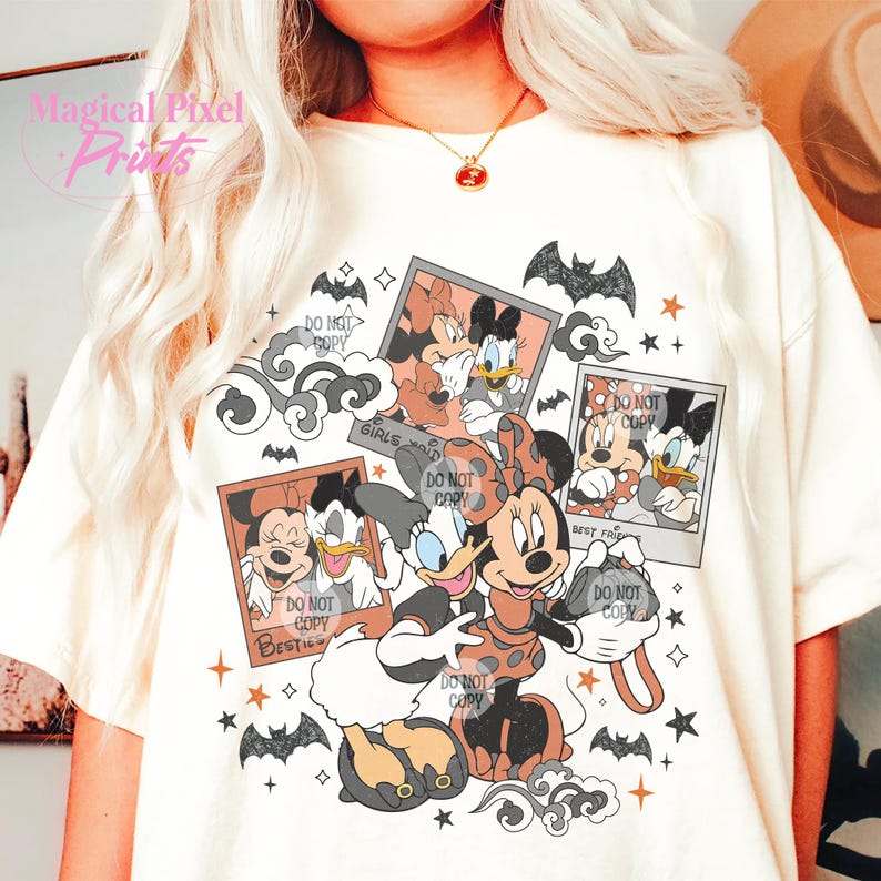 Op de afbeelding: Een wit T-shirt met een grafische print van Mickey Mouse en Minnie Mouse verkleed als heksen. De grafiek bevat de tekst "Girls just wanna have fun" en "Best friends".