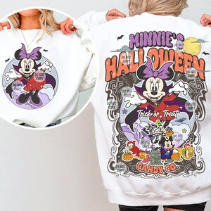 May include: White sweatshirt with a graphic print of Minnie Mouse dressed as a vampire with the text "Minnie's Halloween Trick or Treat Candy Co."