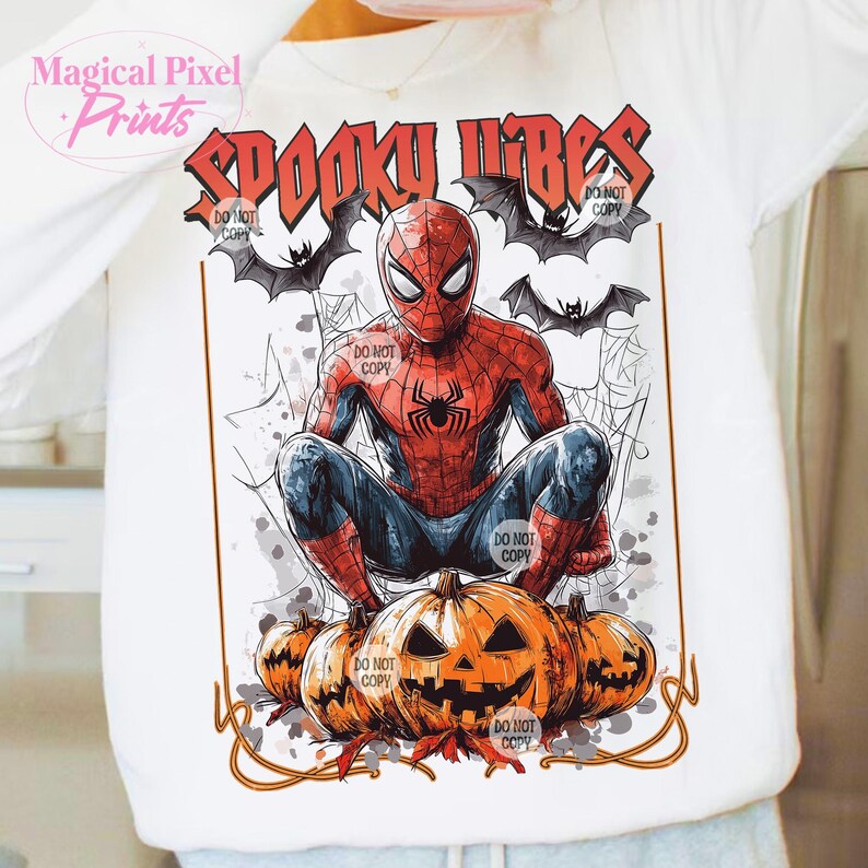 K&ouml;nnte beinhalten: Wei&szlig;es Langarmshirt mit einem Spiderman-Motiv und dem Text "Spooky Vibes". Das Design umfasst Flederm&auml;use, Spinnweben und geschnitzte K&uuml;rbisse. Das Shirt hat ein Halloween-Thema.