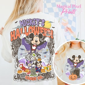 Może przedstawiać: Kremowa koszulka z grafiką o tematyce Halloween. Projekt zawiera Myszka Miki przebranego za wampira, otoczonego przez inne postacie Disneya w kostiumach na Halloween, z napisem "Mickey's Halloween" i "Trick or Treat".