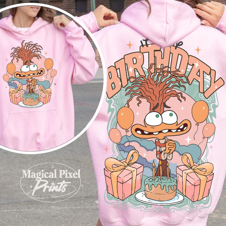 Może przedstawiać: R&oacute;żowa bluza z kapturem z postacią z kresk&oacute;wki trzymającą tort urodzinowy i prezenty. Na plecach bluzy nadrukowany jest napis "It's My Birthday".