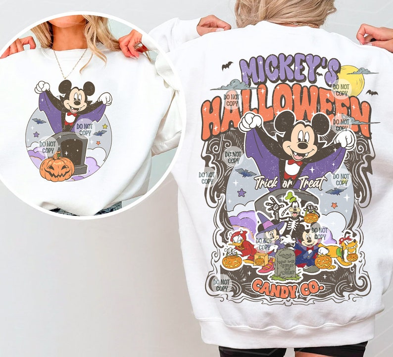 Może przedstawiać: Biała bluza z nadrukiem o tematyce Halloween. Projekt zawiera Myszkę Miki przebraną za wampira, dynię i napis "Mickey's Halloween". Widoczne są r&oacute;wnież inne postacie. Widoczne są r&oacute;wnież słowa "Trick or Treat" i "Candy Co."