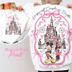 May include: White sweatshirt with a pink and white design featuring Mickey and Minnie Mouse kissing in front of a pink and white castle. The text "Happiest Couple on Earth" is written in pink above the castle.