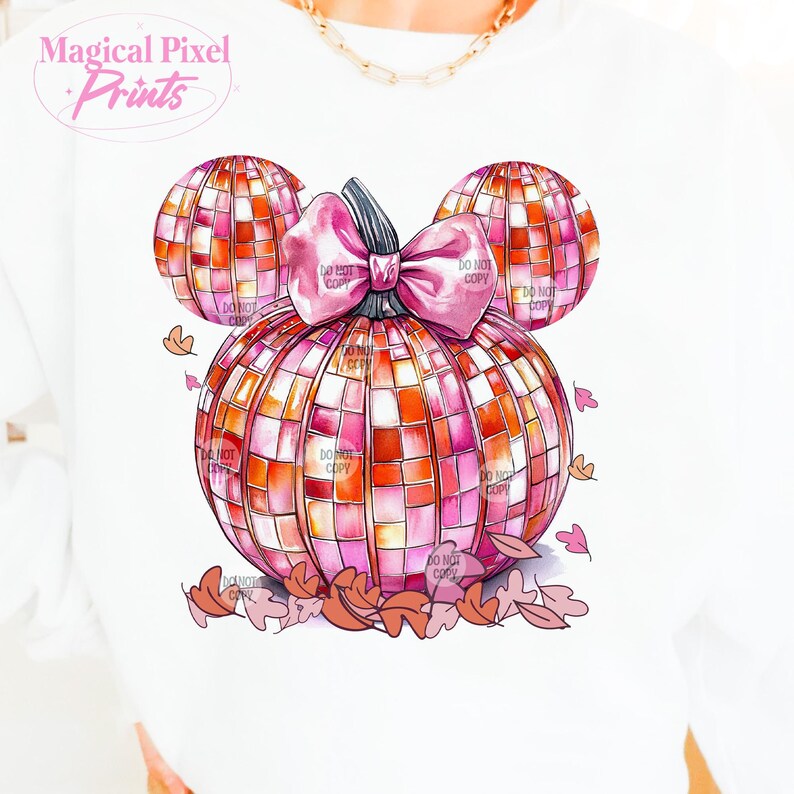 K&ouml;nnte beinhalten: Ein rosa und orangefarbener K&uuml;rbis mit einer rosa Schleife, die wie Mickey-Maus-Ohren geformt ist, mit Herbstbl&auml;ttern, die um ihn herum verstreut sind.