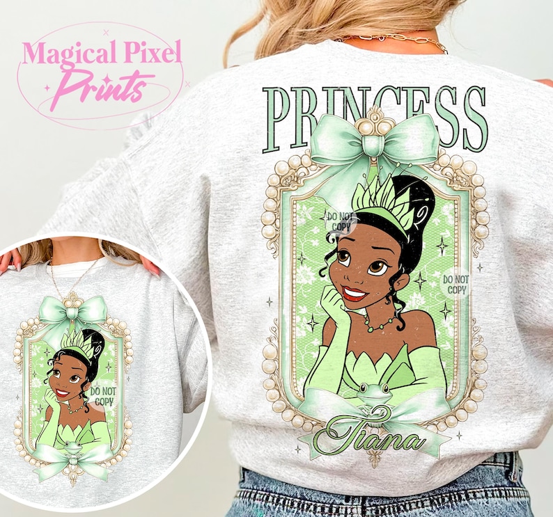 May include: A gray sweatshirt with a green princess design. The design features a portrait of a cartoon princess with a green dress and crown, surrounded by a gold frame with pearls. The text "PRINCESS" is printed in green above the design, and the name "Tiana" is printed below the design.