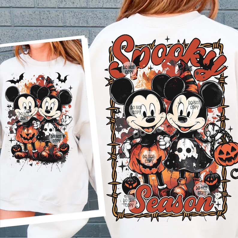 May include: White sweatshirt featuring a Halloween-themed design with Mickey and Minnie Mouse characters dressed in costumes, holding jack-o'-lanterns. The words "Spooky Season" are displayed in a decorative font, with bats and barbed wire accents.