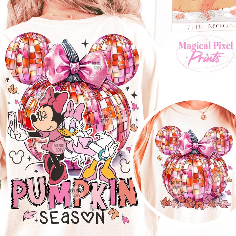 K&ouml;nnte beinhalten: Ein wei&szlig;es T-Shirt mit einem pinkfarbenen und orangenen K&uuml;rbisdesign. Der K&uuml;rbis besteht aus einer Discokugel und hat eine rosa Schleife oben drauf. Mickey Mouse und Daisy Duck stehen vor dem K&uuml;rbis. Der Text "Pumpkin Season" steht unter dem K&uuml;rbis.