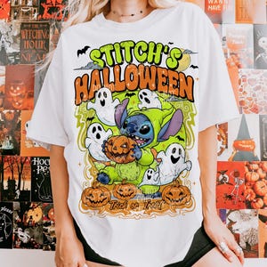Puede incluir: Camiseta blanca con un dise&ntilde;o de Halloween. El dise&ntilde;o incluye el texto "Stitch's Halloween", Stitch, fantasmas y calabazas. La camiseta tiene cuello redondo y mangas cortas, ideal para la temporada de sustos.