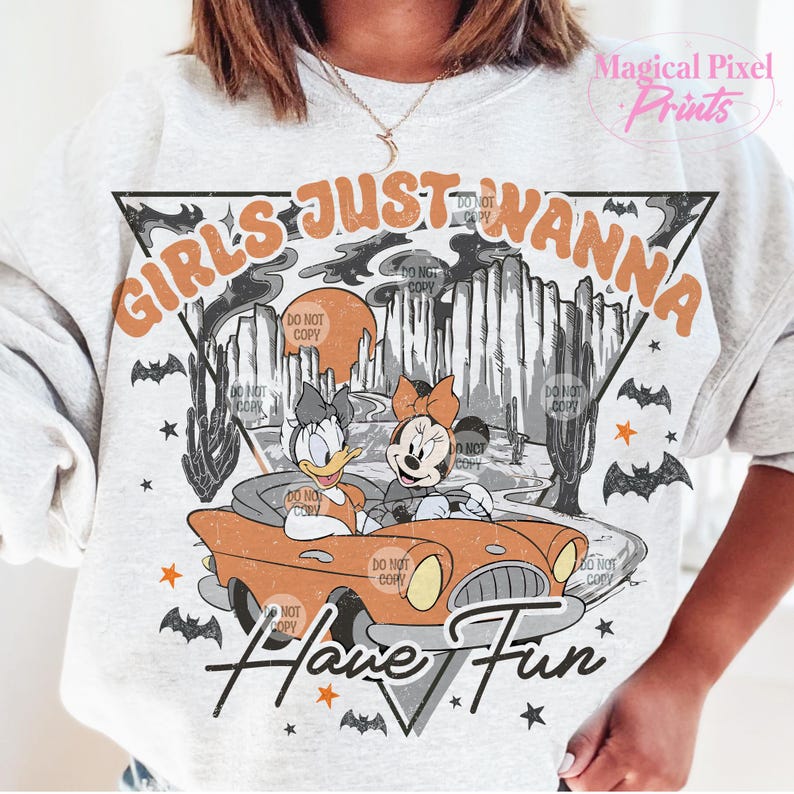 May include: A grey sweatshirt with a vintage-style graphic featuring Mickey Mouse and Donald Duck driving a car. The text "Girls Just Wanna Have Fun" is printed in orange and black letters.