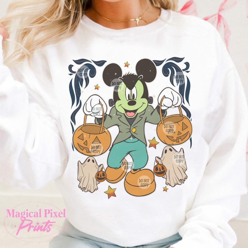 May include: A white sweatshirt with a cartoon image of Mickey Mouse dressed in a green jacket and blue pants holding two orange jack-o'-lantern buckets. The image is surrounded by a black and white floral design and stars.